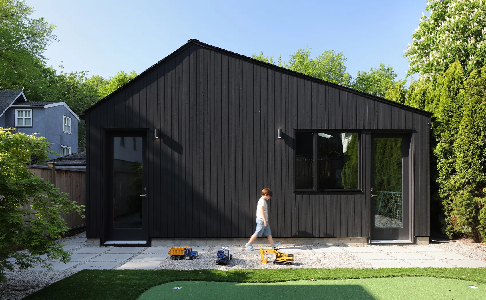 2013-PlayHouse-Web-ExteriorGarage-Landscape-EmaPeter.webp